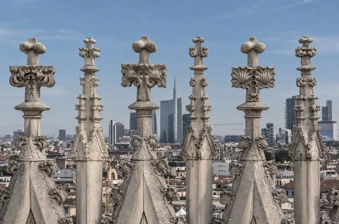 Rows of marble pinnacles with the Porta Nuova towers behind